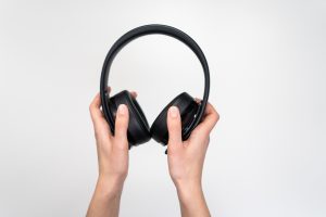 person-holding-black-wireless-headphones-3945668