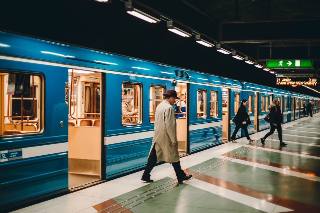 Aus einer blauen U-Bahn steigen Menschen aus.