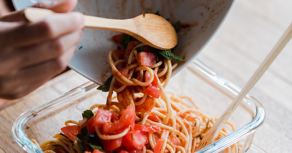 Tupperware Tupperdose wird mit Essensresten befüllt